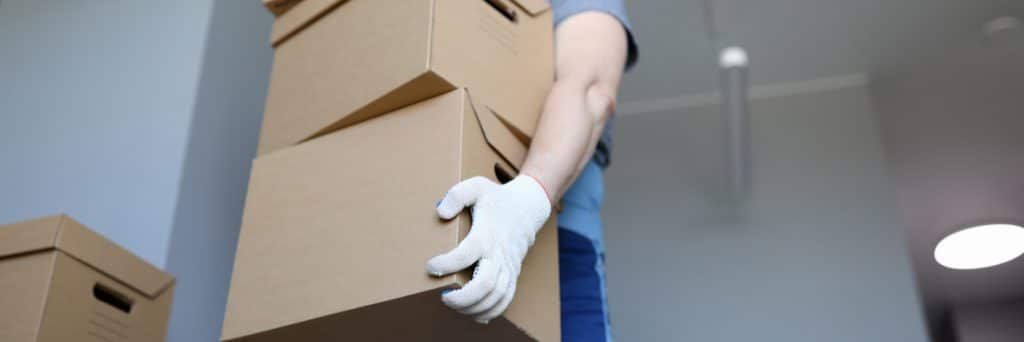 man-work-clothes-gloves-carries-cardboard-boxes-1024x342